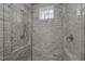 Close up of tile in the shower that includes shower head and window for natural light at 2908 Stubble Field Dr, Raleigh, NC 27613