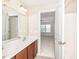 Bright bathroom featuring double sinks, a large mirror, and an open doorway to the bedroom at 3000 Summerhouse Rd, Cary, NC 27519