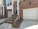 Charming brick townhome showcasing a private entrance with a well-kept one car garage at 3000 Summerhouse Rd, Cary, NC 27519