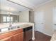 Spacious kitchen features stainless steel dishwasher and a view into adjacent dining and staircase at 3000 Summerhouse Rd, Cary, NC 27519