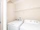 Laundry room with white appliances and a wire rack shelf for storage and organization at 3000 Summerhouse Rd, Cary, NC 27519