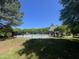 Community pool area surrounded by lush greenery and secure fencing, perfect for summer relaxation at 3000 Summerhouse Rd, Cary, NC 27519