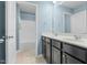 Comfortable bathroom with double sinks, neutral-tiled floor, and shower at 311 Windrush Ln, Durham, NC 27703