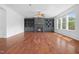Cozy living room featuring a fireplace, built-in shelving, hardwood floors and large windows at 311 Windrush Ln, Durham, NC 27703