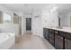 Luxurious main bathroom featuring a soaking tub, walk-in shower, and dual vanity sinks at 311 Windrush Ln, Durham, NC 27703