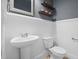 Charming powder room featuring stylish wainscoting, decorative mirror, and modern fixtures at 311 Windrush Ln, Durham, NC 27703