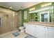 Well-lit bathroom with double vanity sinks, a glass-enclosed shower, neutral tile, and contemporary fixtures at 3210 Environ Way, Chapel Hill, NC 27517