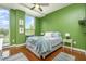 Comfortable bedroom with green walls, hardwood floors, a ceiling fan, and natural light from large windows at 3210 Environ Way, Chapel Hill, NC 27517