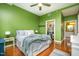 Serene bedroom with green walls, hardwood floors, a closet, and access to an ensuite bathroom at 3210 Environ Way, Chapel Hill, NC 27517
