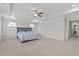 A neutral bedroom features tray ceiling, ceiling fan, and plush carpeting at 323 Oak Branch Trl, Garner, NC 27529