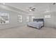 The primary bedroom includes a ceiling fan, tray ceiling, plush carpet, and several windows at 323 Oak Branch Trl, Garner, NC 27529