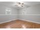 Bright bedroom with hardwood floors, two windows, and a ceiling fan with light at 3402 Pat Tilley Rd, Bahama, NC 27503