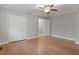 Bedroom featuring hardwood floors, a ceiling fan with light, closet doors, and two entry doors at 3402 Pat Tilley Rd, Bahama, NC 27503