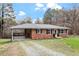 Brick home featuring a covered carport, mature trees, and well-kept landscaping at 3402 Pat Tilley Rd, Bahama, NC 27503