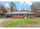 Charming brick home with a covered carport and a well-manicured lawn at 3402 Pat Tilley Rd, Bahama, NC 27503