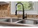 Stylish kitchen sink with a modern black faucet and tiled backsplash by a bright window at 3402 Pat Tilley Rd, Bahama, NC 27503