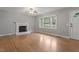 Cozy living room features a fireplace, large window and hardwood floors at 3402 Pat Tilley Rd, Bahama, NC 27503