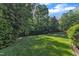 Private backyard space featuring a well-kept lawn, mature trees, and greenery, creating a serene outdoor oasis at 3824 Laurel Hills Rd, Raleigh, NC 27612