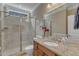 Bathroom featuring a glass-enclosed shower, granite countertop, and a large, framed mirror at 3824 Laurel Hills Rd, Raleigh, NC 27612