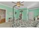 Airy bedroom offers a four-poster bed, ceiling fan, mint-colored walls, and plenty of space for study at 3824 Laurel Hills Rd, Raleigh, NC 27612