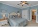 Inviting bedroom with light blue walls, ceiling fan, and double doors, creating a relaxing space at 3824 Laurel Hills Rd, Raleigh, NC 27612