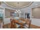 Elegant dining room with hardwood floors, wainscoting, chandelier, and a large window for natural light at 3824 Laurel Hills Rd, Raleigh, NC 27612