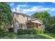 Beautiful backyard view of the brick home featuring a covered porch and lush landscaping in a serene setting at 3824 Laurel Hills Rd, Raleigh, NC 27612