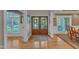 Elegant foyer featuring hardwood floors, a decorative rug, double doors, and natural light from nearby windows at 3824 Laurel Hills Rd, Raleigh, NC 27612