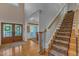 Grand foyer with hardwood floors, staircase with carpet runner, and double doors leading to the outside at 3824 Laurel Hills Rd, Raleigh, NC 27612