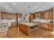 Spacious kitchen features granite countertops, stainless steel appliances, island with bar seating and light hardwood floors at 3824 Laurel Hills Rd, Raleigh, NC 27612