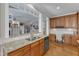 Kitchen features granite countertops, stainless steel appliances, a breakfast bar and light hardwood floors at 3824 Laurel Hills Rd, Raleigh, NC 27612