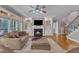 Cozy living room featuring a fireplace, staircase, and view to large windows at 3824 Laurel Hills Rd, Raleigh, NC 27612