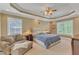Spacious main bedroom featuring a tray ceiling, seating area, and neutral decor at 3824 Laurel Hills Rd, Raleigh, NC 27612