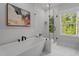 Bathroom features a modern tub and a separate glass-enclosed shower, along with a window at 3866 Keohane Dr, Durham, NC 27705
