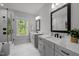Spacious bathroom features dual sinks, gray vanity, sleek mirrors and glass-enclosed shower at 3866 Keohane Dr, Durham, NC 27705