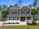 Charming blue two-story home featuring a welcoming front porch and manicured landscaping at 3866 Keohane Dr, Durham, NC 27705