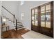 Bright foyer featuring hardwood floors, double doors and a staircase with white risers at 3866 Keohane Dr, Durham, NC 27705