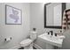 Modern half-bathroom featuring a sleek vanity, stylish mirror, and neutral color palette at 3866 Keohane Dr, Durham, NC 27705