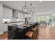Modern kitchen island featuring a black countertop with seating and stylish pendant lights at 3866 Keohane Dr, Durham, NC 27705