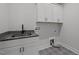 Modern laundry room with stylish patterned floors, granite countertops, and ample cabinet space at 3866 Keohane Dr, Durham, NC 27705