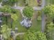 An aerial view of a brick house featuring a well-maintained yard, driveway, and surrounding trees at 406 N Wakefield St, Zebulon, NC 27597