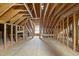 Unfinished attic space showcasing natural light through a window, framed walls, and plywood flooring at 406 N Wakefield St, Zebulon, NC 27597