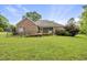 An expansive backyard showcasing the home's brick exterior, screened porch, and grassy landscape at 406 N Wakefield St, Zebulon, NC 27597