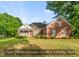 Charming brick home featuring a covered front porch and mature landscaping at 406 N Wakefield St, Zebulon, NC 27597