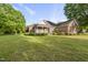 Inviting front yard showcasing a brick home with a cozy front porch and manicured bushes at 406 N Wakefield St, Zebulon, NC 27597