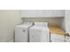 Functional laundry room with white appliances, storage cabinets, and folding counter at 406 N Wakefield St, Zebulon, NC 27597