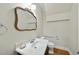 An updated powder room featuring a decorative mirror and hardwood floors at 406 N Wakefield St, Zebulon, NC 27597