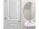 Bathroom featuring a pedestal sink, oval mirror, and white door offering a clean and modern aesthetic at 408 Ember St, Sanford, NC 27330