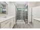 Modern bathroom with white cabinets, quartz countertops, gray tile flooring, and a walk-in shower at 409 Summit Trail Dr, Hillsborough, NC 27278