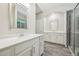 Well-lit bathroom featuring double sinks, white cabinetry, and a glass-door shower at 409 Summit Trail Dr, Hillsborough, NC 27278